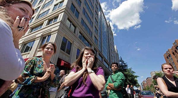 Office workers gather on the sidewalk in downtown Washington, Tuesday, moments after a 5.9 magnitude tremor shook the nation's capitol. (c) J. Scott Applewhite/Associated Press