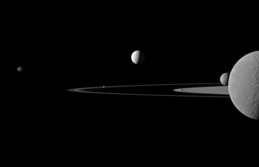 Brightly reflective Enceladus (504 kilometers, 313 miles across) appears above the center of the image. Saturn's second largest moon, Rhea (1528 kilometers, 949 miles across), is bisected by the right edge of the image. The smaller moon Mimas (396 kilometers, 246 miles across) can be seen beyond Rhea also on the right side of the image. (c) NASA