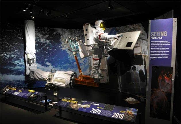 276600-hubble A re-installment of the crucial moment in 2009, when astronaut John Grunsfeld installed the new Wide Field Camera 3, the device that currently captures many of Hubble’s most amazing images. (c) AMNH\R. Mickens