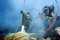Divers taking a coral core sample. [Via eurekalert.org]
