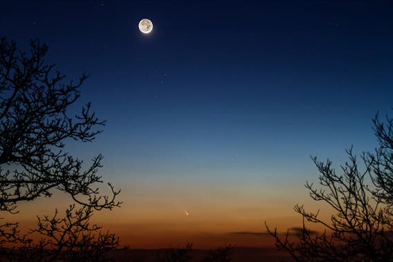 A time exposure photo of the comet by an unusually bright moon caught by the same Jean-Luc Dauvergne.