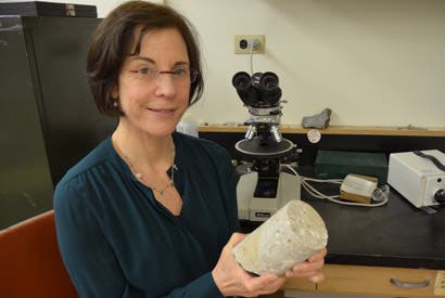 Marie Jackson holds a 2,000-year-old sample of maritime concrete from the first century B.C. Santa Liberata harbor site in Tuscany. 