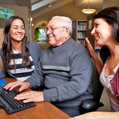 girls-teaching-old-man-how-to-use-a-computer-lg