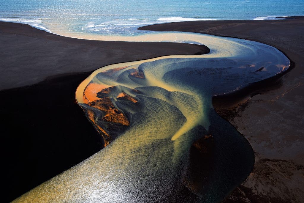 One of a series of aerial shots taken from a helicopter over the fabulous river deltas in South Iceland.  This one depicts one river winding its way to the ocean.  The brilliant colors are a result of mineral deposits picked up by the glacial waters as they flow towards the sea. We were lucky to shoot on a gorgeously sunny day