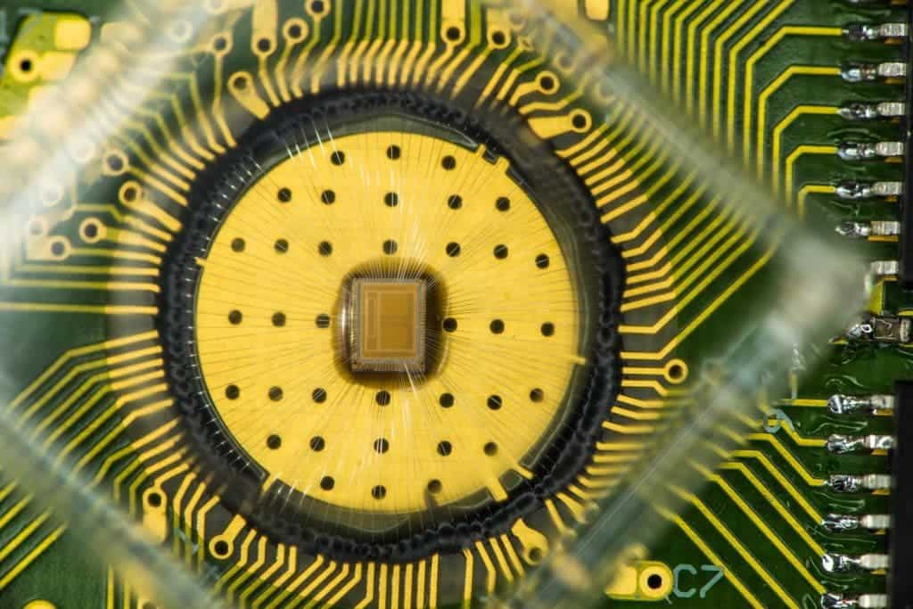 The experimental multi-bit PCM chip used by IBM scientists is connected to a standard integrated circuit board. The chip consists of a 2 × 2 Mcell array with a 4- bank interleaved architecture. The memory array size is 2 × 1000 μm × 800 μm. The PCM cells are based on doped-chalcogenide alloy and were integrated into the prototype chip serving as a characterization vehicle in 90 nm CMOS baseline technology. Credit: IBM Research