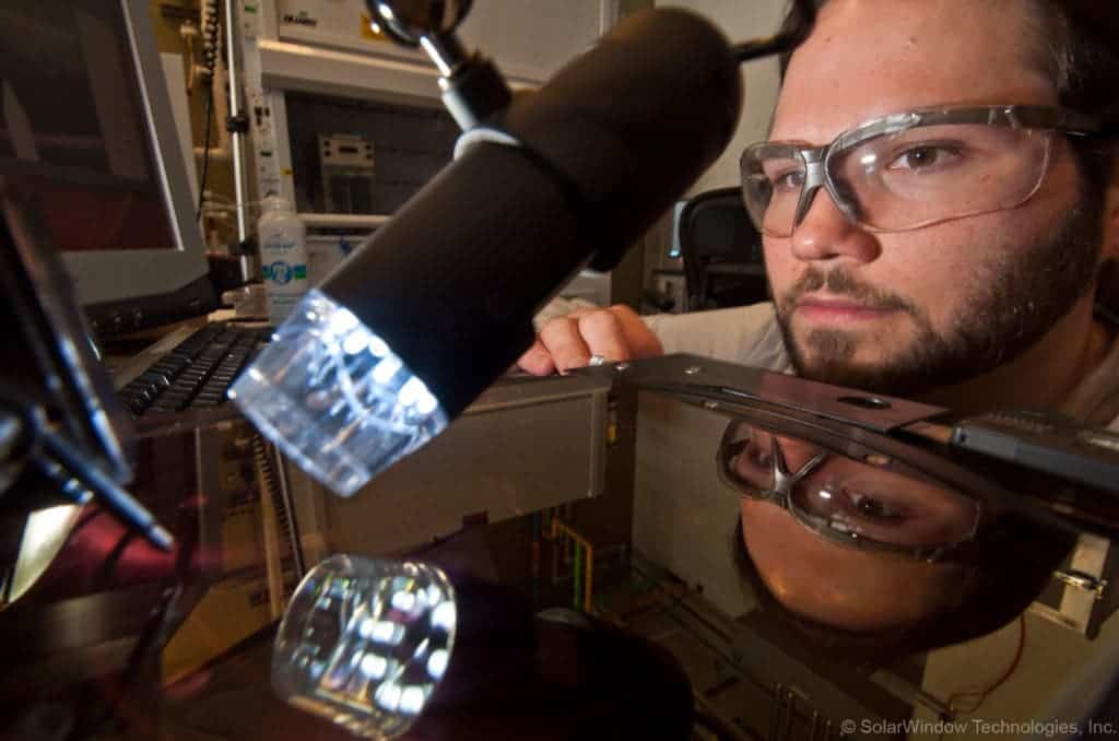 Dr.Scott Hammond testing the coating under artificial light. Image credits SolarWindow.