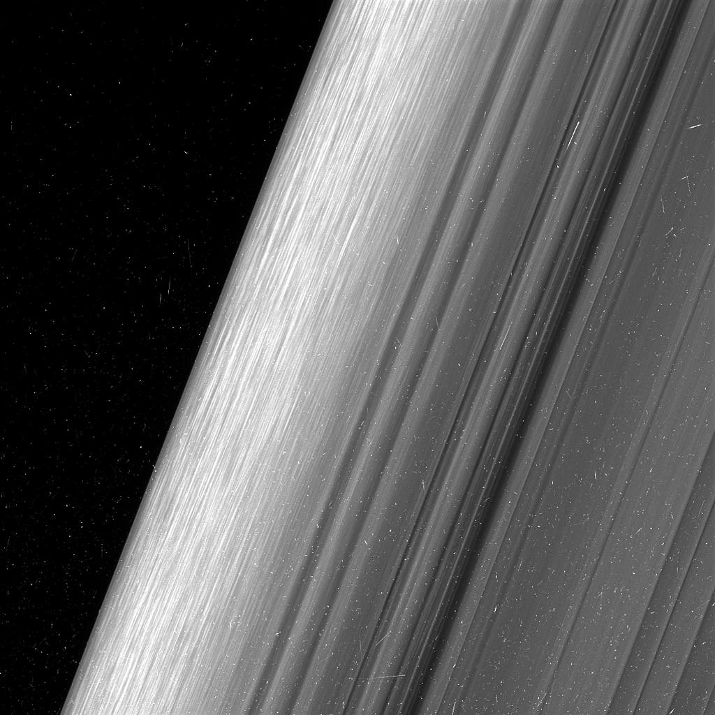 The view here is of the outer edge of the B ring, at left, which is perturbed by the most powerful gravitational resonance in the rings: the "2:1 resonance" with the icy moon Mimas. This means that, for every single orbit of Mimas, the ring particles at this specific distance from Saturn orbit the planet twice. This results in a regular tugging force that perturbs the particles in this location. Credit: NASA. 