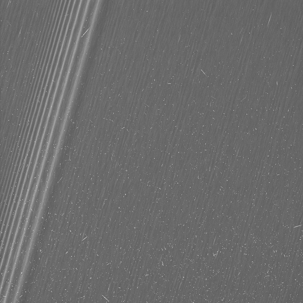 A region in Saturn's A ring. The level of detail is twice as high as this part of the rings has ever been seen before. The view contains many small, bright blemishes due to cosmic rays and charged particle radiation near the planet. Credit: NASA. 