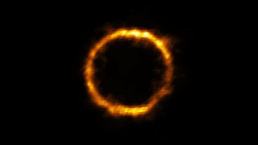 Using ALMA astronomers have revealed an extremely distant galaxy that looks surprisingly like our Milky Way. The galaxy, SPT0418-47, is gravitationally lensed by a nearby galaxy, appearing in the sky as a near-perfect ring of light. (ALMA (ESO/NAOJ/NRAO), Rizzo et al.)