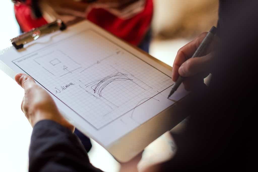 Engineer drawing a sketch on notepad.