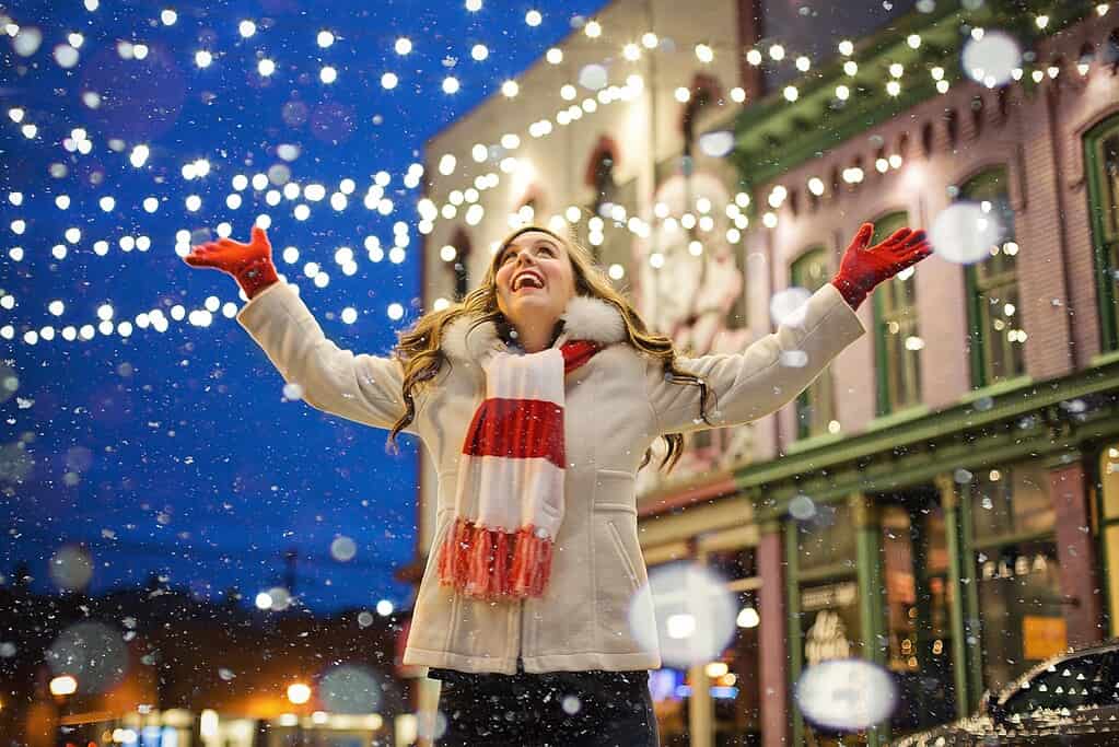 Happy woman admiring Christmas lights. 