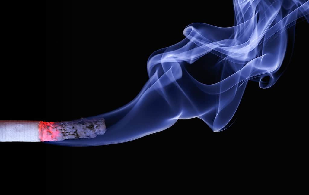 Closeup of cigarette with smoke.