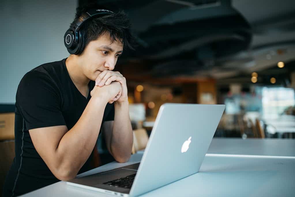 Man wearing headphones studying at laptop